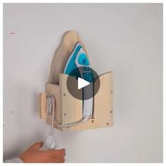 a person is holding a wooden shoe rack with shoes on it and an object hanging from the wall