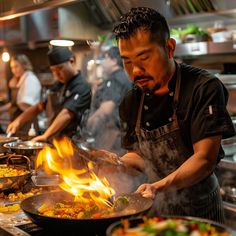 a man cooking food in a kitchen with flames coming out of the pots and pans