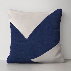 a blue and white pillow sitting on top of a table