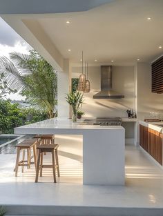 an outdoor kitchen with bar stools next to it