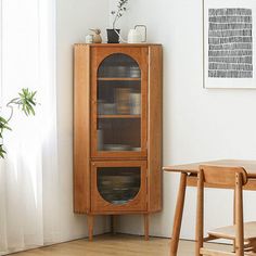 a wooden cabinet sitting in the corner of a room next to a table and chairs