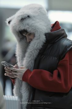 a person wearing a furry coat and holding a cell phone