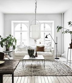 a living room filled with furniture next to a wooden floor covered in lots of windows