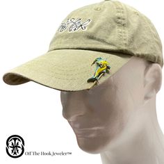 a hat with a bird embroidered on the front and side, sitting on top of a mannequin head