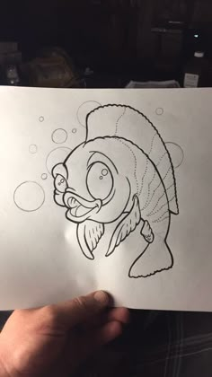 someone holding up a drawing of a fish with bubbles in it's mouth and eyes