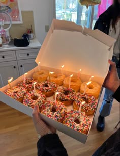 a box filled with lots of donuts covered in sprinkles