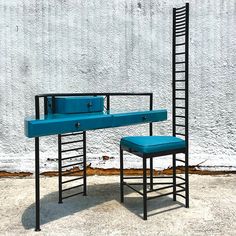 a blue bench and chair sitting in front of a white wall with a ladder leaning up against it