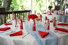 the table is set with red napkins and silverware