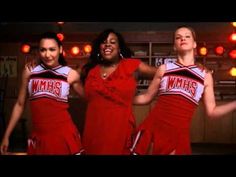 three women in red dresses are dancing together