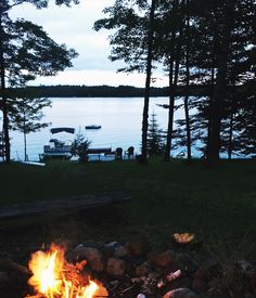 a campfire is lit in front of a lake