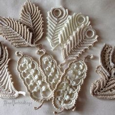 crocheted leaves are arranged on a white sheet