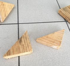 three pieces of wood sitting on top of a tile floor next to each other,