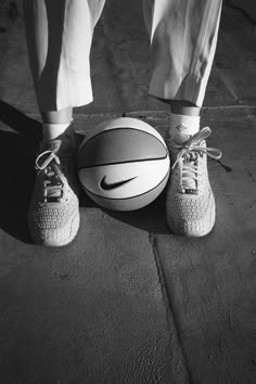 a person standing next to a basketball on the ground