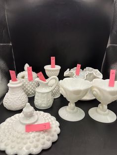 several white vases with pink stickers on them