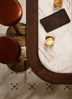 a marble topped table with two glasses on it and a leather pad next to it