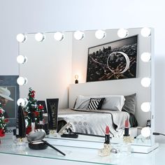 a bedroom with a vanity mirror, lights and makeup products on the table in front of it