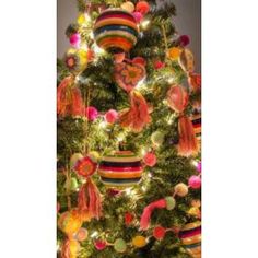 a christmas tree decorated with colorful ornaments and lights is shown in this image, it's all lit up