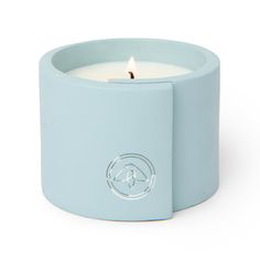 a blue candle holder with a lit candle in it's center and a circular logo on the front