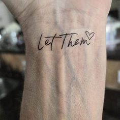 a person with a tattoo on their arm that says let them