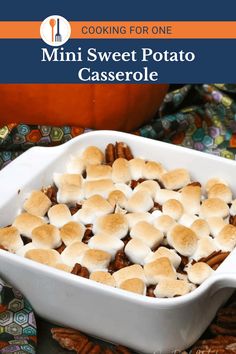 a casserole dish with marshmallows and pecans in the background