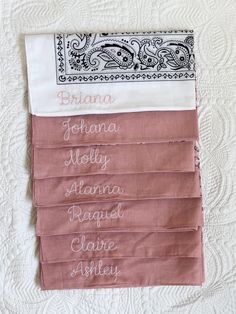 the names of different types of fabric on a white quilted bed sheet with an embroidered border