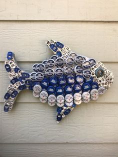 a fish made out of beer cans on the side of a building