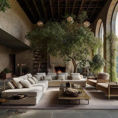 a living room filled with lots of furniture and a tree in the middle of it