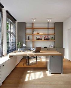 a home office with wooden floors and built - in shelving