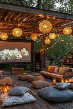 an outdoor theater with lights and pillows on the floor, in front of a pergolated