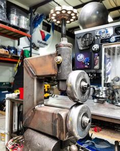 a machine that is sitting on top of a piece of metal in a room filled with tools