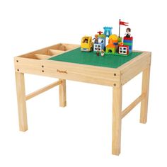 a child's wooden table with legos on the top and green plastic covering