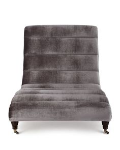 a gray velvet chair with wooden legs