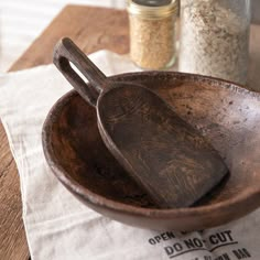 a wooden bowl and spoon sitting on top of a table