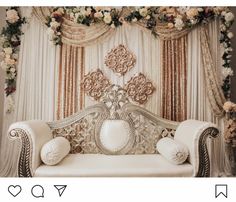 a white couch sitting under a window covered in flowers