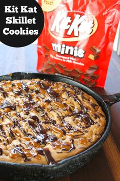 a chocolate chip cookie in a cast iron skillet next to a box of milk