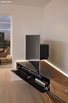 an entertainment center in the corner of a room with wood flooring and white walls