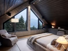 a bedroom with a large bed and two chairs in front of a window that looks out onto the mountains