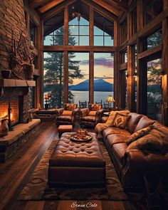 a living room filled with lots of furniture and a fire place in front of a large window