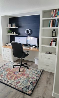 a home office with two computer screens and a rug on the floor in front of it