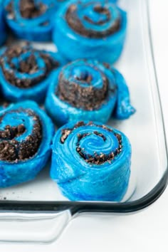 there are blue rolls with chocolate frosting on them