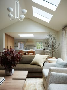 a living room filled with furniture and a skylight over the top of the ceiling