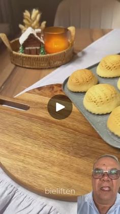 a man standing in front of a wooden cutting board filled with cookies on top of a table