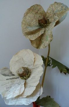 two paper flowers sitting on top of a table