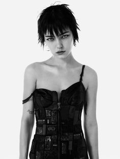 a black and white photo of a woman with short hair wearing a corset