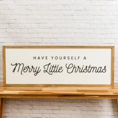 a sign that says have yourself merry little christmas on it next to a wooden bench