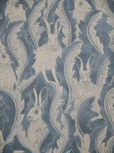 a blue and white wallpaper with rabbits on it