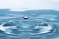 a water droplet is shown in the middle of a body of water with ripples