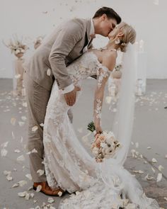 a bride and groom kissing in front of petals