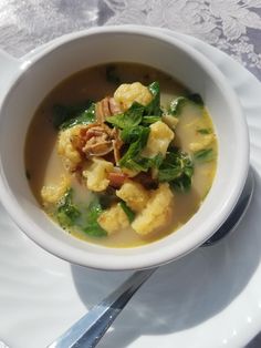 a white bowl filled with soup on top of a plate