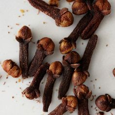 cloves and nuts on a white surface with some brown stuff in the middle